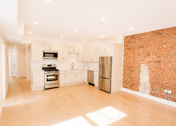 A kitchen with a refrigerator, oven, and microwave.