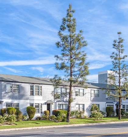 an apartment building on the corner of a street with a blue sky