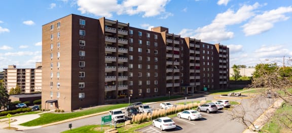 a large apartment building with many balconies and a parking lot in front of it