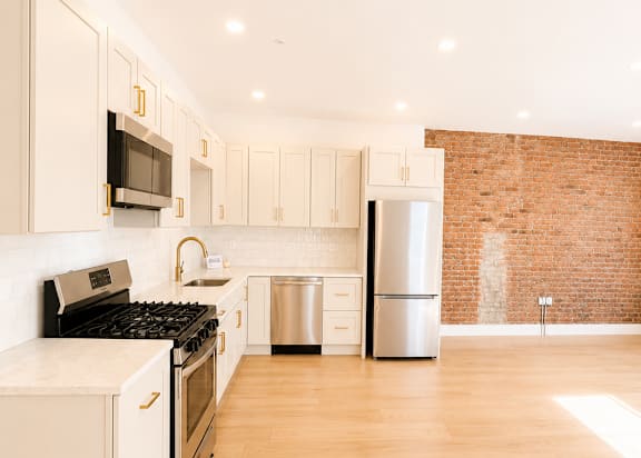A kitchen with a black stove top oven and white cabinets.