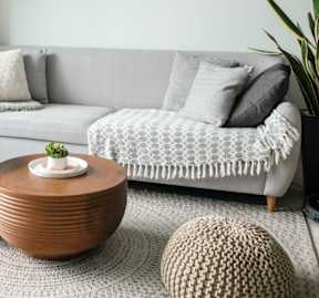 Cozy living room with a grey couch, wood table, and wall art representing comfortable living at Willow Creek Apartments.