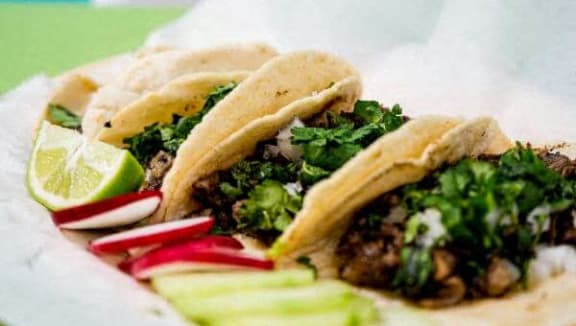 a plate of tacos and pickles on a table