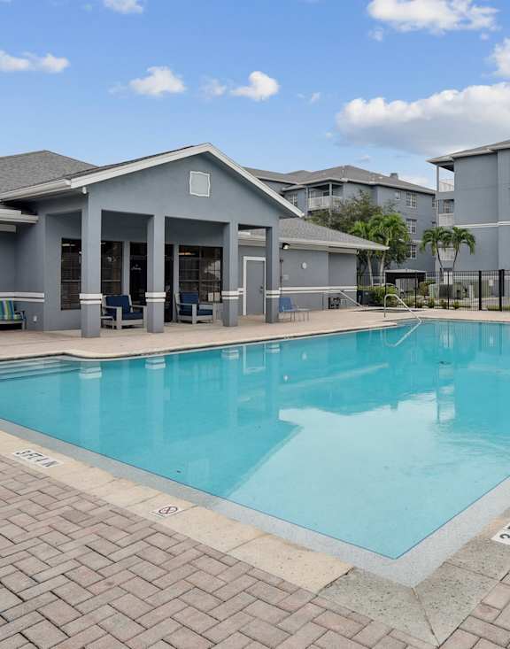 A swimming pool surrounded by a brick patio.