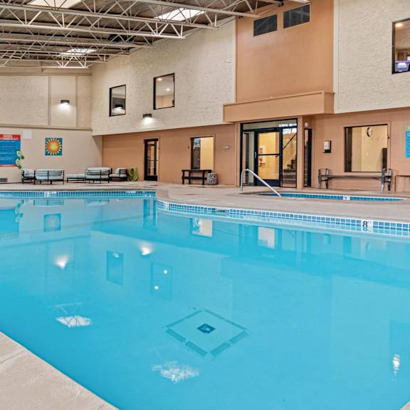 A large indoor swimming pool with a blue tiled bottom.