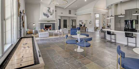 a living room with white couches and rattan chairs