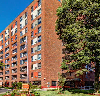 a tall brick building with trees in front of it