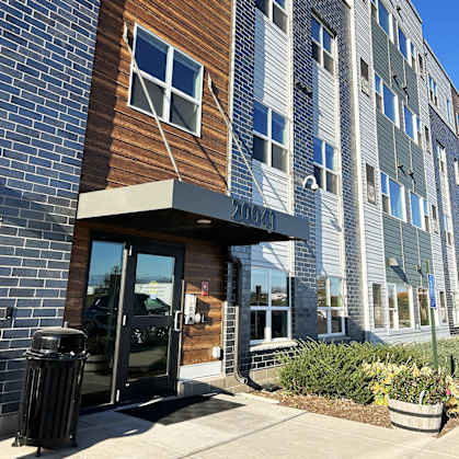 a brick building with a glass door and a brown and gray facade