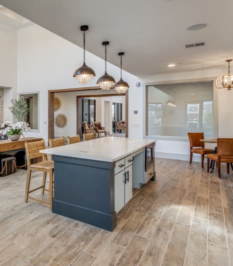 the living room and kitchen of a house with a fireplace and a blue kitchen island