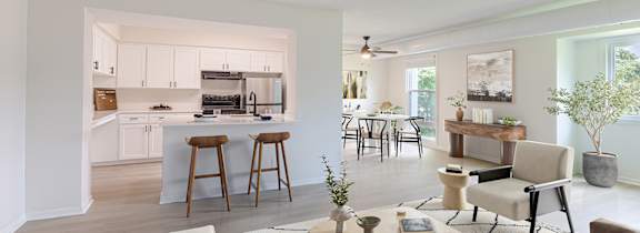 A modern living room with a view of the kitchen