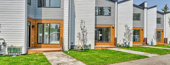 a row of houses with a sidewalk and grass