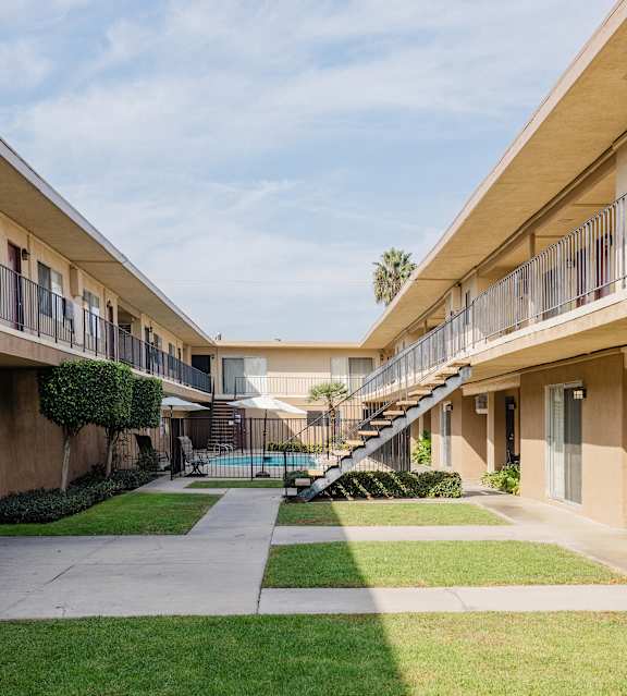 A sunny day at the apartment complex with green grass and a clear blue sky.