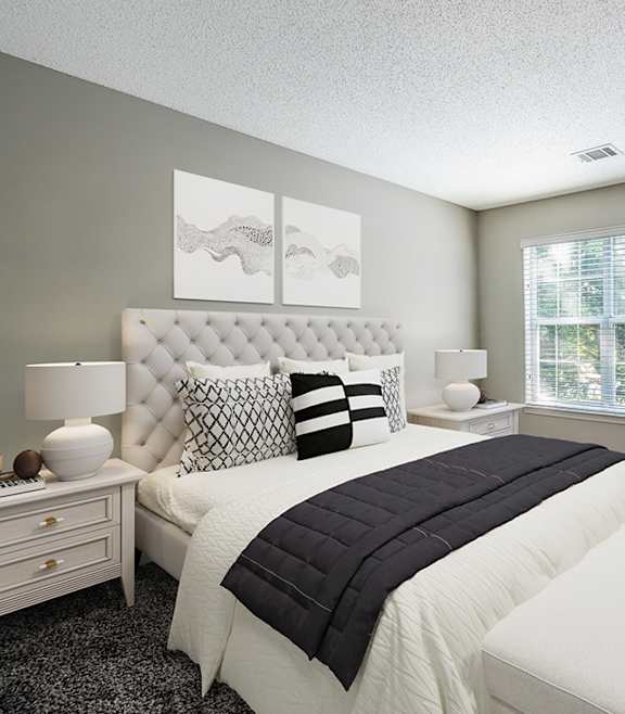 a bedroom with a bed and a chair at The Village Apartments, North Carolina, 27615