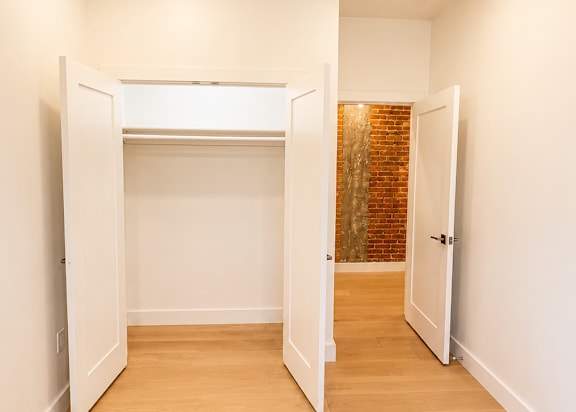 A hallway with a brick wall and white walls.