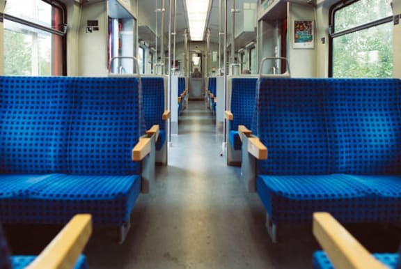 the inside of a train with blue benches