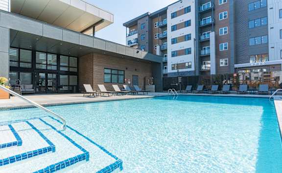 A swimming pool with a blue tiled edge and a metal ladder.