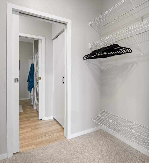 A walk-in closet with hangers on the rack.