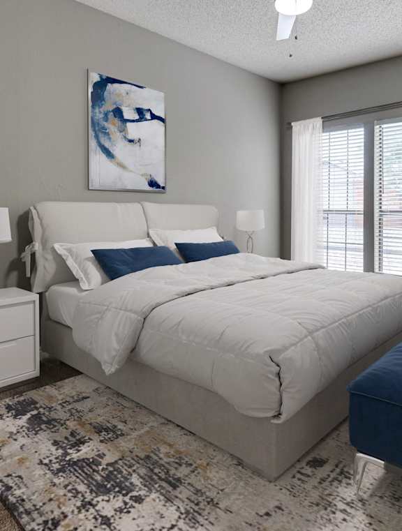 A bedroom with a bed, nightstand, and a ceiling fan.