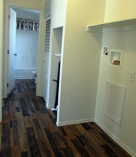 a bedroom with hardwood floors and white walls