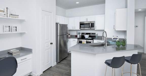 A modern kitchen with a bar stool and a refrigerator.