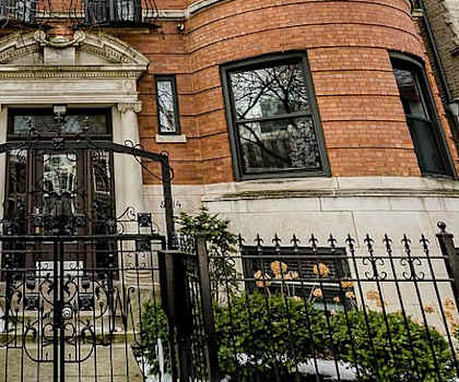 A red brick building with a black iron gate in front.