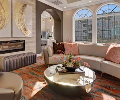 The resident lounge with a fireplace, couches, decorations, plush chairs, and coffee tables at Latitude 31 Apartments. 