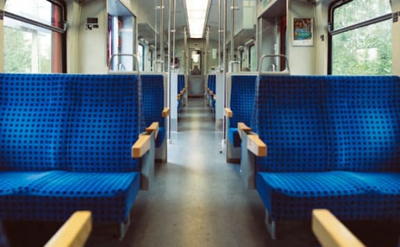 the inside of a train with blue benches