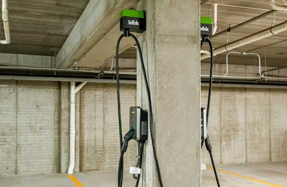 Two electric vehicle charging stations are installed in a parking garage.
