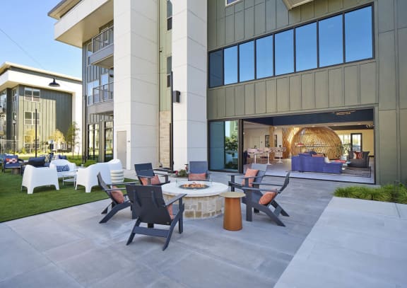 a patio with chairs and a table in front of a building