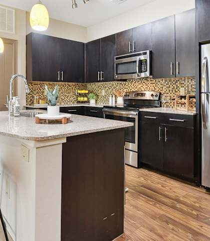 a kitchen with stainless steel appliances and a marble counter top at Lakeline East Apartments, Texas, 78613