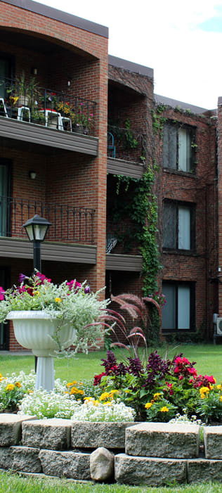 exterior of apartment building with flower bed in courtyard