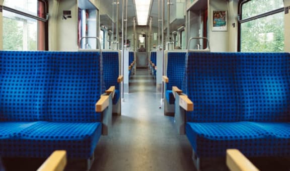 the inside of a train with blue benches