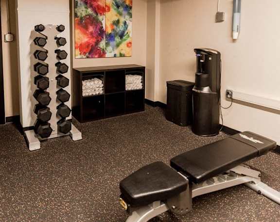 a fitness room with a bench and dumbbells at Cosmopolitan, Washington