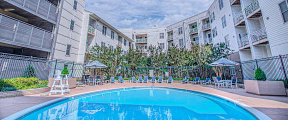 A large white apartment building with a pool in the courtyard at The Mark at Dulles Station, Herndon