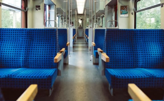 the inside of a train with blue benches