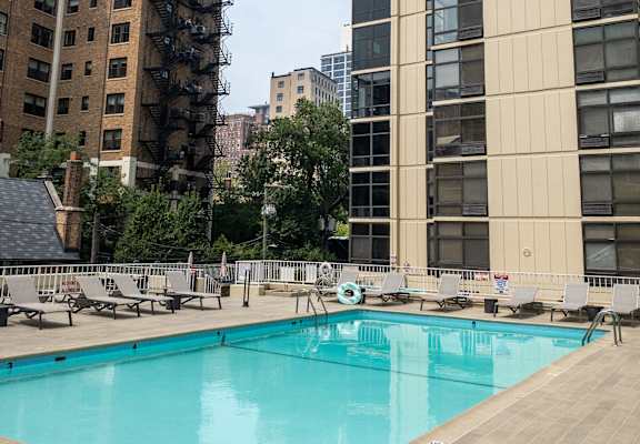 A large swimming pool in front of a tall building.