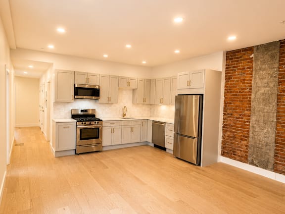 A kitchen with a refrigerator, oven, and microwave.