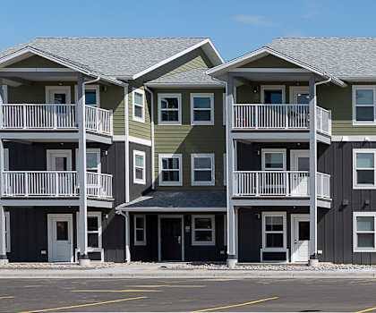 Image of Pioneer Village apartments from across the parking lot looking at the front of the building.