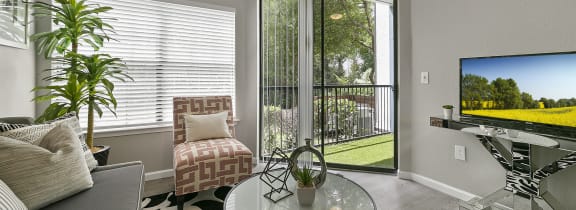 a living room with a sliding glass door leading to a balcony