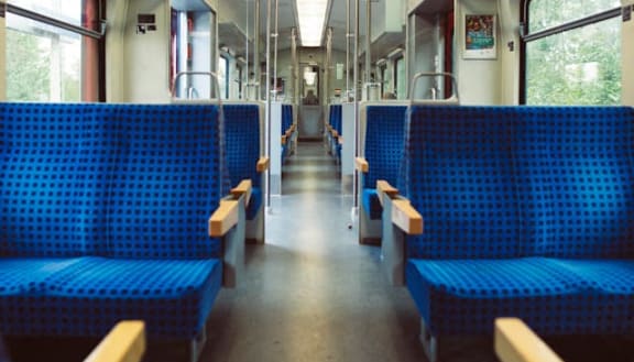 the inside of a train with blue benches