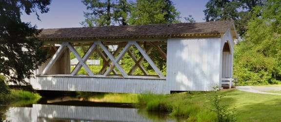 a covered bridge with its reflection in a body of water