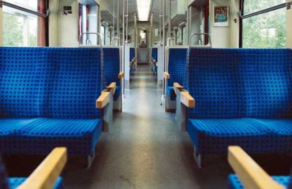 the inside of a train with blue benches