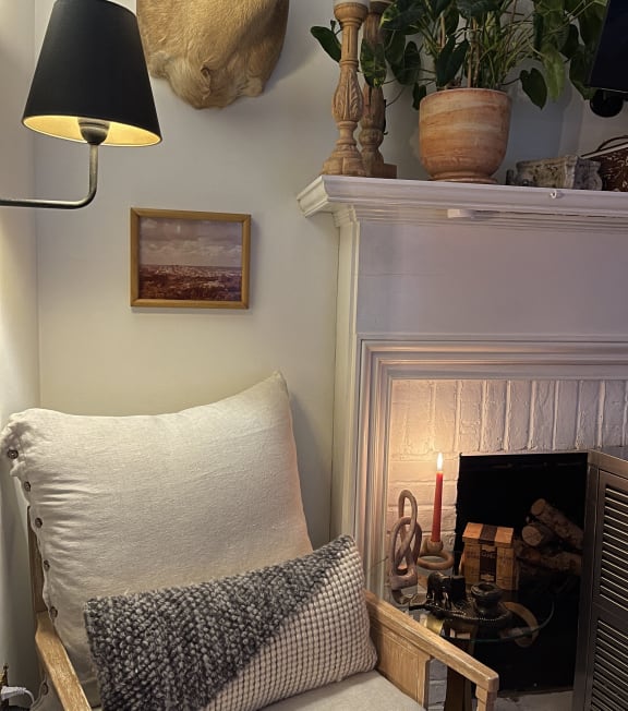 a chair with a pillow in front of a fireplace