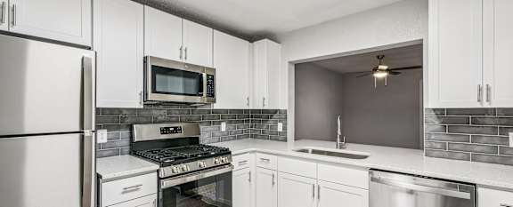 A kitchen with white cabinets and stainless steel appliances.