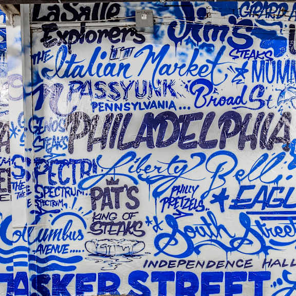 A wall covered in blue writing with Philadelphia written in the middle.