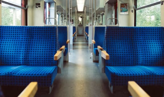 the inside of a train with blue benches