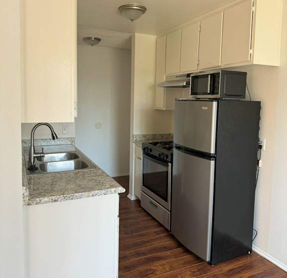 A kitchen with a black refrigerator and stove.