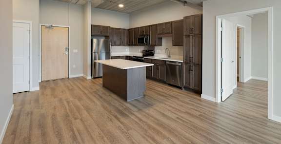 A kitchen with wooden floors and a large island in the middle.
