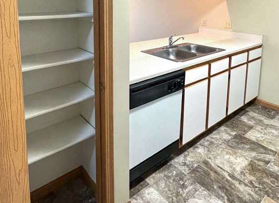 a kitchen with white and brown cabinets and a pantry