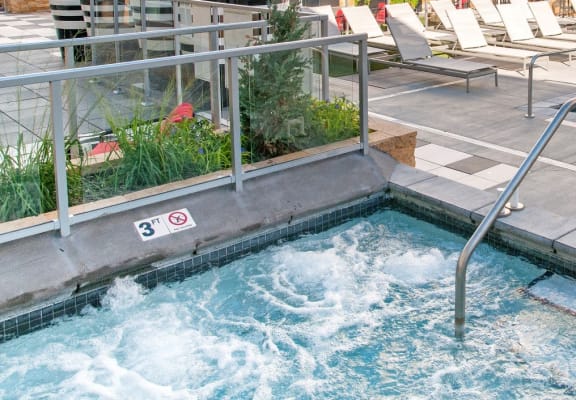 a hotel pool with a jacuzzi and chairs on the side of it