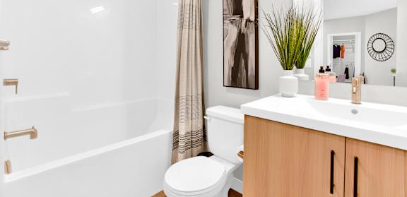A white bathroom with a toilet, sink, and shower.